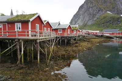 Houses by lake and mountains against sky