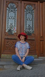 Full length of woman sitting outside building