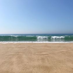 Scenic view of beach against clear blue sky