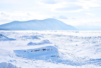 Scenic view of snowcapped mountains by sea against sky