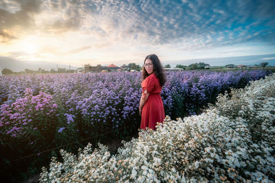 Rear view of woman standing on field against sky