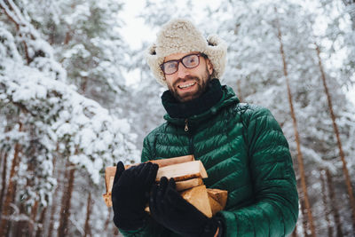 Portrait of man holding ice cream against trees