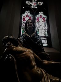 Midsection of man sitting by window in temple