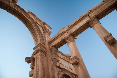 Low angle view of old ruins against clear blue sky