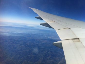 Aerial view of airplane wing over landscape