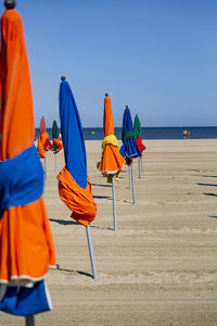 Multi colored umbrellas on beach against clear sky