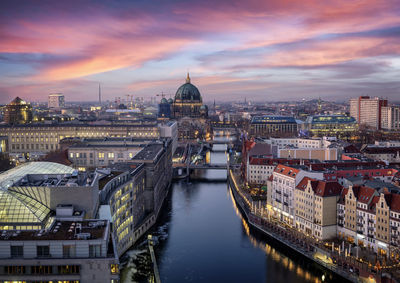 Aerial view of buildings in city at sunset
