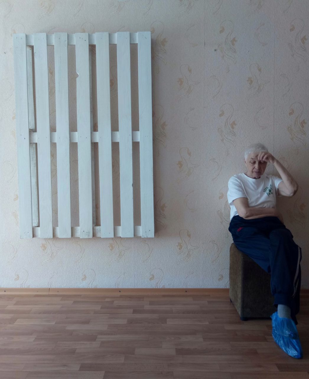 one person, full length, casual clothing, real people, leisure activity, lifestyles, indoors, women, front view, adult, flooring, emotion, sadness, architecture, wall - building feature, looking, wood, depression - sadness, contemplation