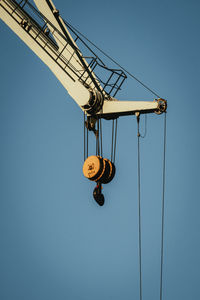 Low angle view of crane against clear sky