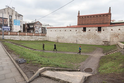 People on building by city against sky