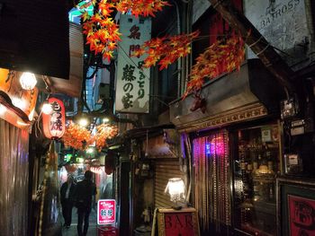 Illuminated store by road at market