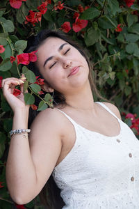 Portrait of young woman standing against plants