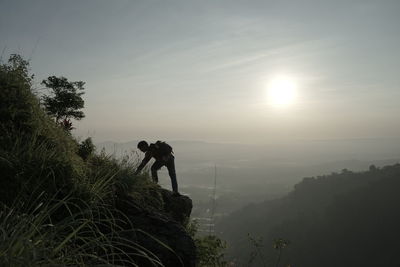 People on mountain against sky during sunset