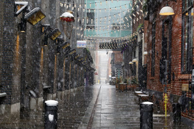 People walking on wet street in city