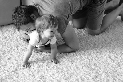 Rear view of father and son on rug