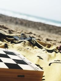 Close-up of paper on beach against sky