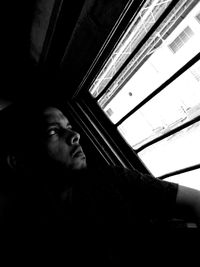 Low angle view of young man against window