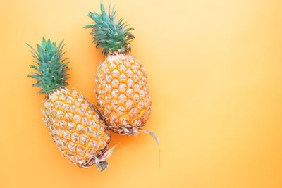 Close-up of fruit on table against orange background