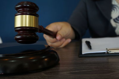 Close-up of hand holding clock on table