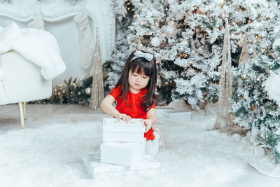 Portrait of smiling young woman sitting on snow