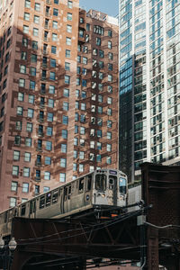 Train on railroad tracks by buildings in city