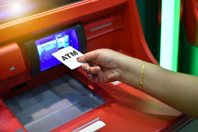 Cropped hand of woman inserting credit card in atm machine