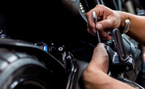 Cropped image of man repairing motorcycle at garage