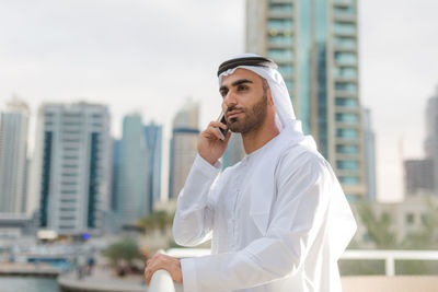 Man in traditional clothing talking over smart phone