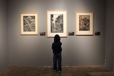 Rear view of woman standing in museum