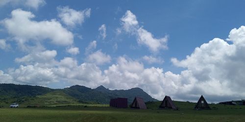 Scenic view of field and houses against sky