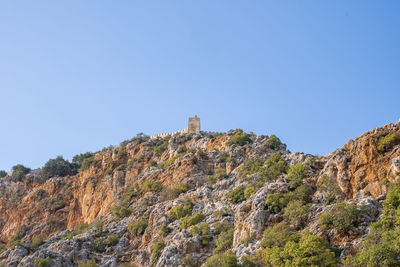 Low angle view of medieval alanya castle on top of rocky mountain