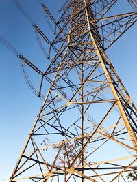 Low angle view of electricity pylon against clear sky