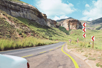 Road by mountain against sky