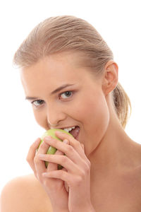 Portrait of young woman holding ice cream against white background