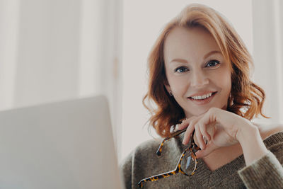 Portrait of young woman using laptop at home