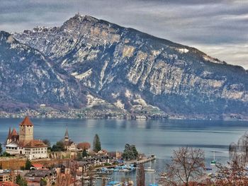 Aerial view of city by lake against sky