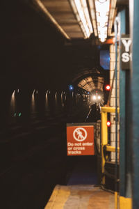 Low angle view of illuminated sign on road in city