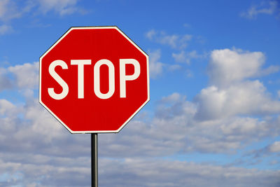 Low angle view of road sign against sky