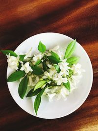 High angle view of white roses in plate on table