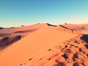 Scenic view of desert against clear blue sky