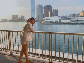 Side view of woman standing by railing