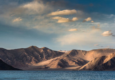 Scenic view of sea and mountains against sky