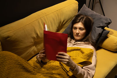 Portrait of woman sitting on sofa at home