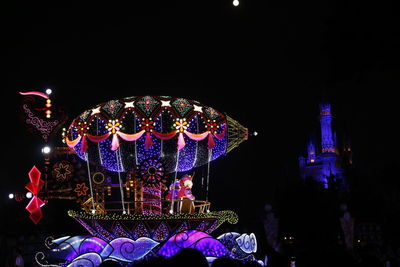 Illuminated ferris wheel at night