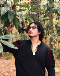 Young man standing against plants