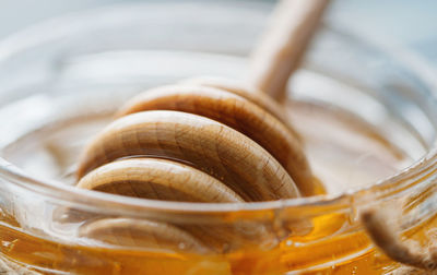 Close-up of honey dipper in jar