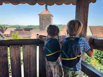 Rear view of man standing by gate
