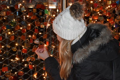 Rear view of woman attaching padlock