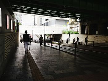 Rear view of people walking on footpath