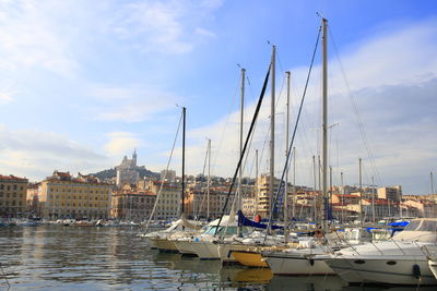 Sailboats moored at harbor